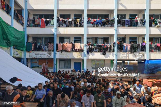 Displaced people gather for the Friday Noon prayers in the yard of a United Nations Relief and Works Agency for Palestine Refugees school in Khan...