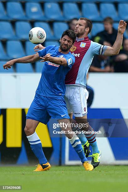 Mirkan Aydin of Bochum is tackled by Ron Vlaar of Aston Villa during the pre-season friendly match between VfL Bochum and Aston Villa at Rewirpower...