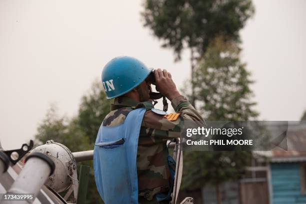 An Indian United Nations peacekeeper looks through binoculars towards M23 positions in Kanyarucinya on the outskirts of Goma in the east of the...