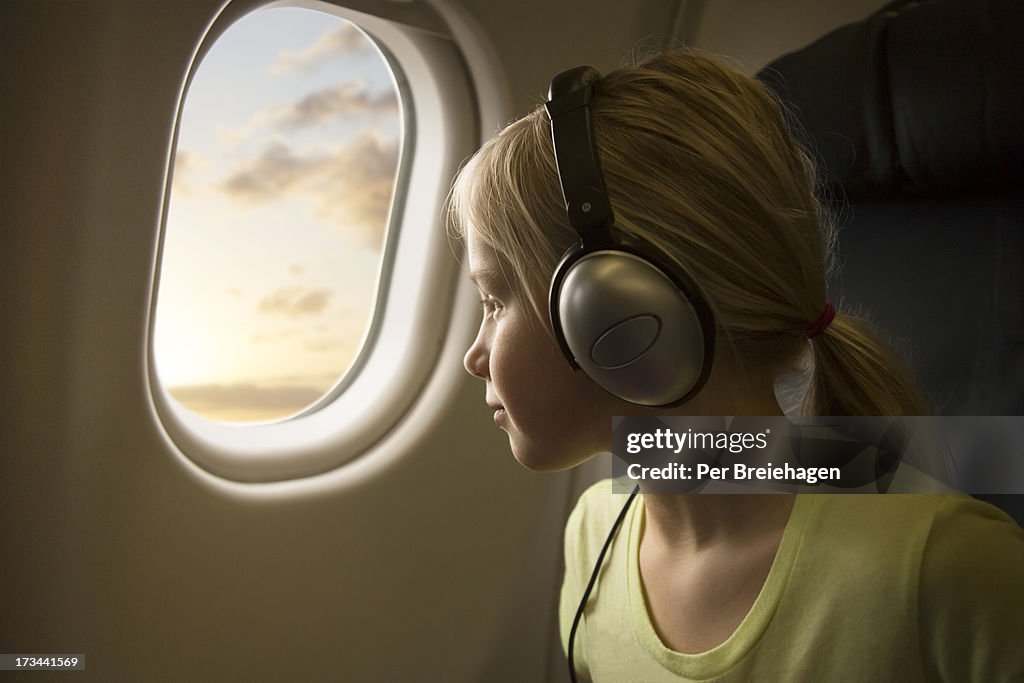 A girl in an airplane looking out of the window