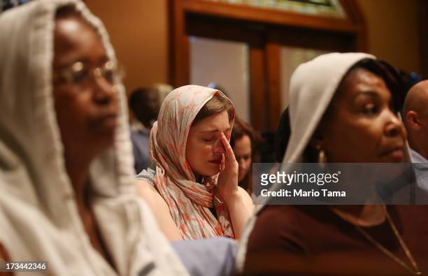 People sit during services honoring Trayvon Martin at Middle Collegiate Church in Manhattan on July 14, 2013 in New York City. George Zimmerman was...