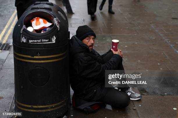 Person sits on the pavement, begging in central London on October 20, 2023.