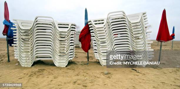 Des transats et des parasols sont rangés sur la plage de Deauville, le 16 mai 2005, rendus inutiles par une météo médiocre lors de la "journée de...