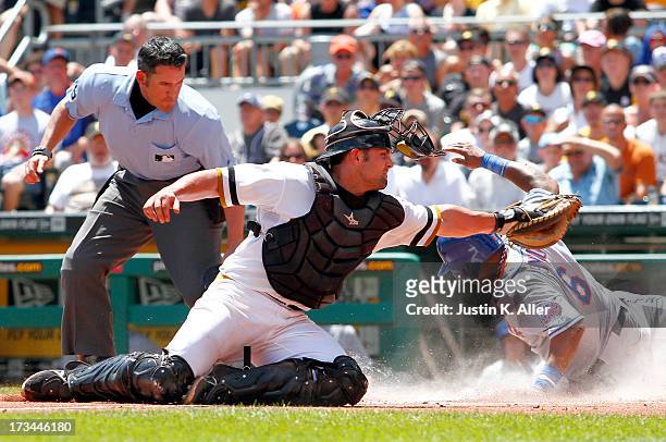 Marlon Byrd of the New York Mets scores on a play at the plate after an RBI single in the first inning against Michael McKenry of the Pittsburgh...