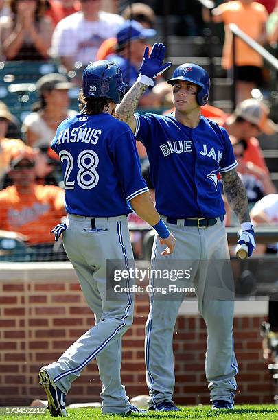 Colby Rasmus of the Toronto Blue Jays celebrates with Brett Lawrie#13 after scoring in the ninth inning against the Baltimore Orioles at Oriole Park...