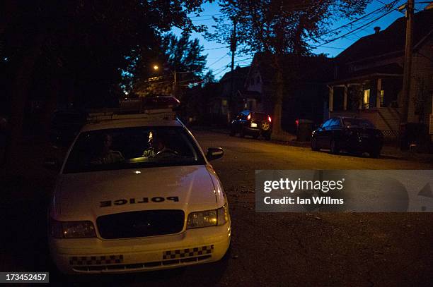 Police guard the fence that keeps people from entering the "red zone" crash site, on July 13, 2013 in Lac-Megantic, Quebec, Canada. A train derailed...