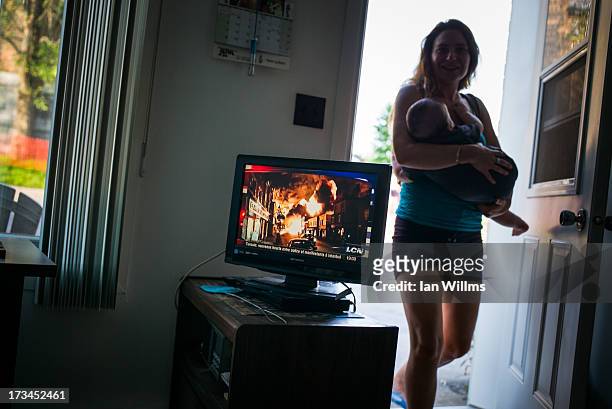 Woman from Montrial visit the home of a local resident who lives about 100 metres from the crash site, on July 13, 2013 in Lac-Megantic, Quebec,...