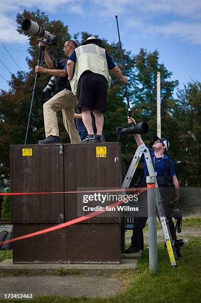 Members of the media attempt to make photographs of the "red zone" crash site, on July 14, 2013 in Lac-Megantic, Quebec, Canada. A train derailed and...