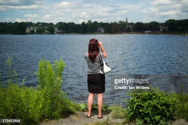 Julie Roy from neighbouring town Sherbrooke looks out over toward the "red zone" crash site, on July 14, 2013 in Lac-Megantic, Quebec, Canada. A...