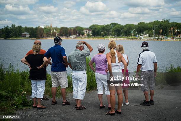 People look out toward the "red zone" crash site, on July 14, 2013 in Lac-Megantic, Quebec, Canada. A train derailed and exploded into a massive fire...
