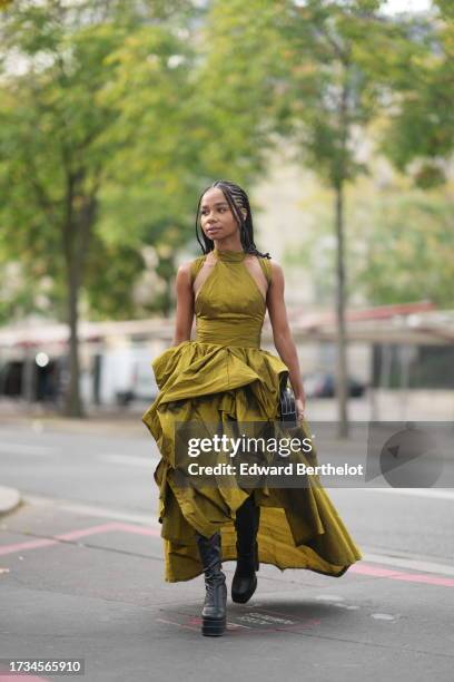 Sarah Monteil wears a gathered ruffled puff bronze colored dress, black leather boots, outside Anrealage, during the Womenswear Spring/Summer 2024 as...