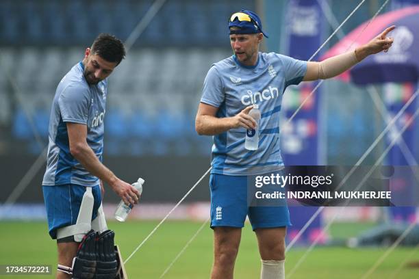 England's Joe Root speaks to teammate Harry Brooks during a training session at the Wankhede stadium in Mumbai on October 20, 2023 ahead of their...