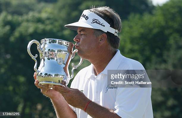 Kenny Perry kisses the trophy after his five-stroke victory at the 2013 U.S. Senior Open Championship at Omaha Country Club on July 14, 2013 in...