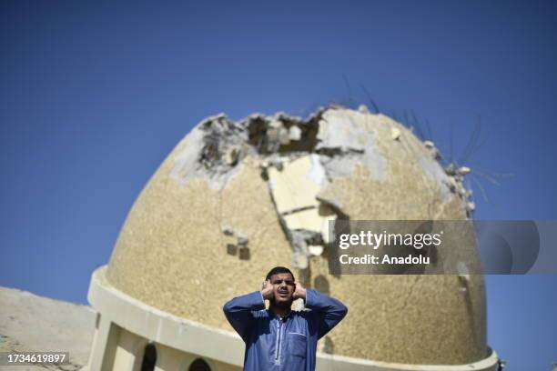 Palestinian recites Salah Azan in the rubble of the Al-Amin Muhammad Mosque, hit by Israeli airstrike, in Khan Yunis, Gaza on October 20, 2023.