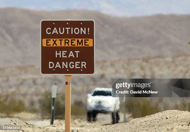 Heat waves rise near a heat danger warning sign on the eve of the AdventurCORPS Badwater 135 ultra-marathon race on July 14, 2013 in Death Valley...