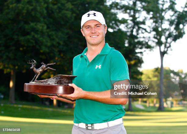 Jordan Spieth holds the trophy after winning a three way five hole sudden death playoff after the final round of the John Deere Classic held at TPC...