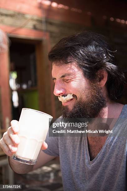 a man sports a milk moustache from coffee - milchbart stock-fotos und bilder