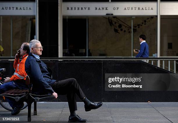 Men sit on a bench outside the Reserve Bank of Australia headquarters in the central business district of Sydney, Australia, on Monday, July 15,...