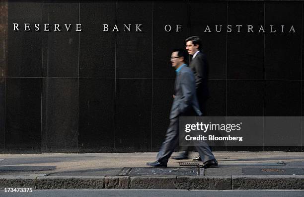 Pedestrians walk past the Reserve Bank of Australia headquarters in the central business district of Sydney, Australia, on Monday, July 15, 2013....