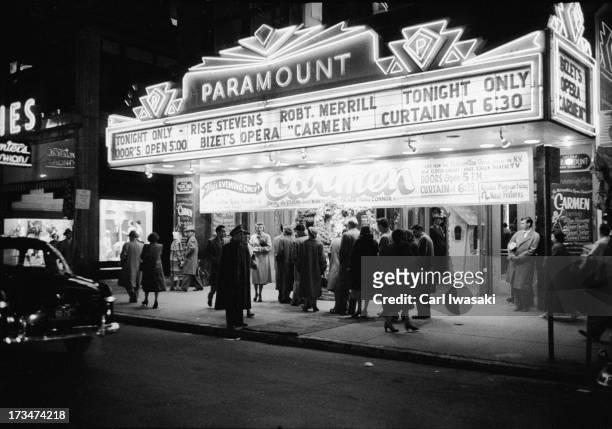 Nighttime view of patrons lined up outside the Paramount theatre for a closed circuit broadcast of the Metropolitan Opera's production of 'Carmen,'...
