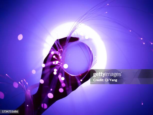 holding a crystal ball wrapped with fiber optics - viollet creative selects stock pictures, royalty-free photos & images