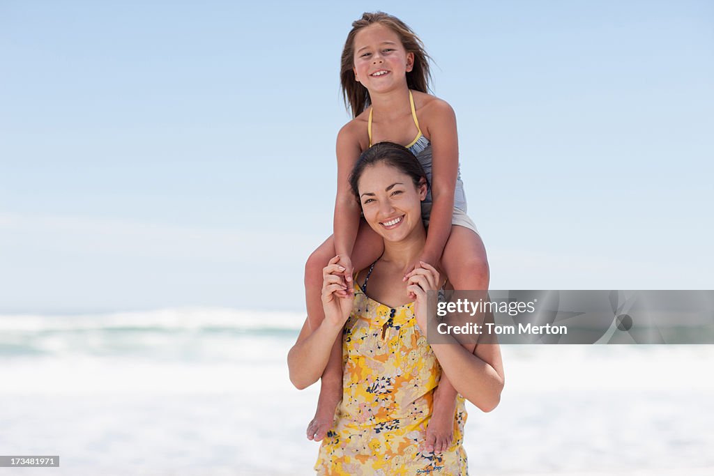 Mother carrying daughter on shoulders