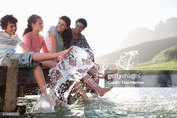 family on dock splashing feet in lake - tween heels stock pictures, royalty-free photos & images