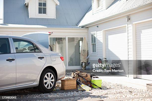 picnic basket, fishing rod, flippers and bags outside car in driveway - driveway stock pictures, royalty-free photos & images