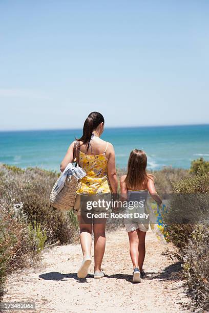 mother and daughter walking on beach path - tote bag stock pictures, royalty-free photos & images