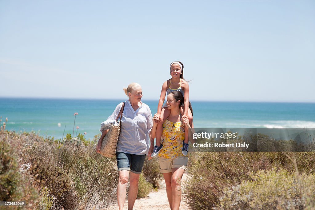 Grandmother with daughter and granddaughter on beach path