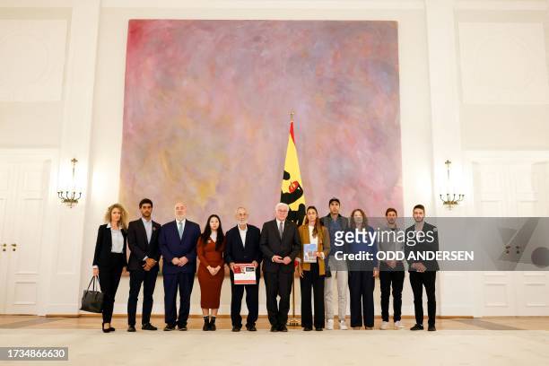 German President Frank-Walter Steinmeier and Israel's Ambassador to Germany Ron Prosor pose with with Gili , Roni Roman and other relatives of German...