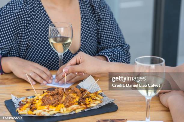 unrecognizable women eating meal, french fries and cheese - comida gourmet stock pictures, royalty-free photos & images