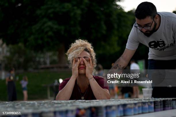 Woman cries while lighting a memorial candle outside Habima on October 20, 2023 in Tel Aviv, Israel. As Israel prepares to invade the Gaza Strip in...