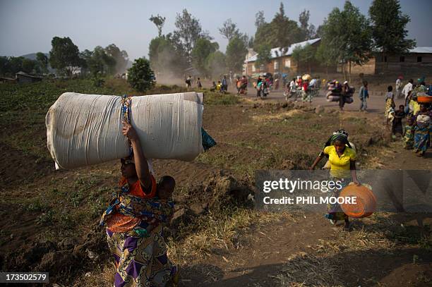 Displaced Congolese flee on July 15, 2013 the area of Kanyarucinya through Munigi on the outskirts of Goma in the east of the Democratic Republic of...