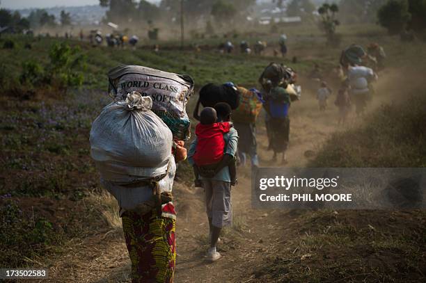 Displaced Congolese flee on July 15, 2013 the area of Kanyarucinya through Munigi on the outskirts of Goma in the east of the Democratic Republic of...