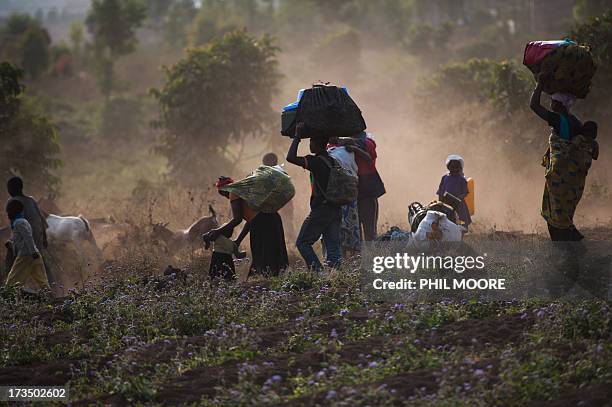 Displaced Congolese flee on July 15, 2013 the area of Kanyarucinya through Munigi on the outskirts of Goma in the east of the Democratic Republic of...