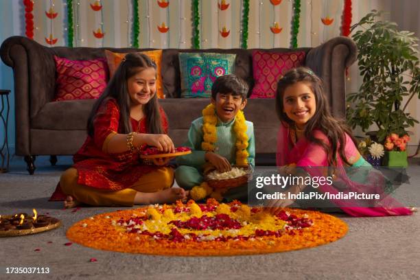 children making floral rangoli together on the occasion of diwali - festival wristband stock pictures, royalty-free photos & images