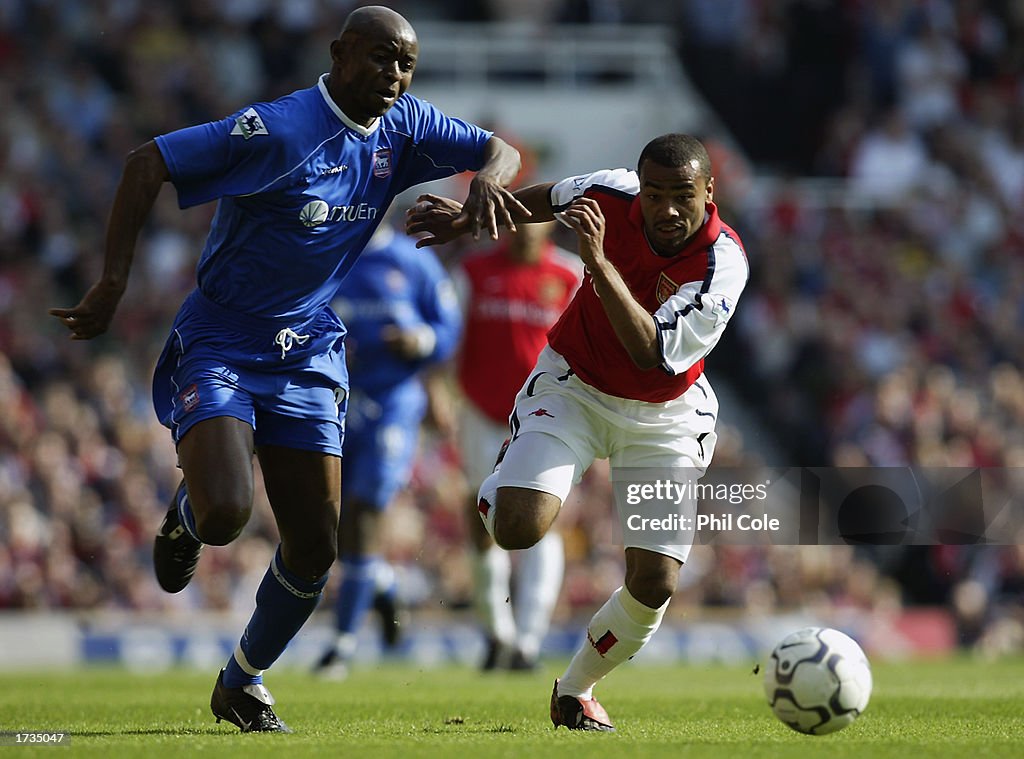Finidi George of Ipswich Town tussles with Ashley Cole of Arsenal for possession of the ball