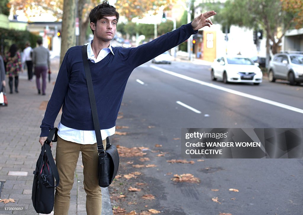 Young Man catching cab from work in Sydney