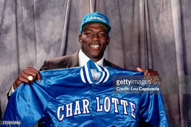 Rookie Larry Johnson of the Charlotte Hornets holds up a Hornets jacket during the 1991 NBA Draft at Madison Square Garden in New York, New York....
