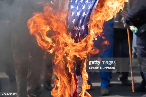 Iranian protesters burn the U.S. Flag during an anti-Israel rally protesting the Israeli air strike on Al-Ahli hospital, in northern Tehran, October...