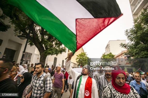 People march from El-Fath Mosque to the French Embassy in Tunis with a giant Palestinian flag, as they stage a protest in support of Palestinians...