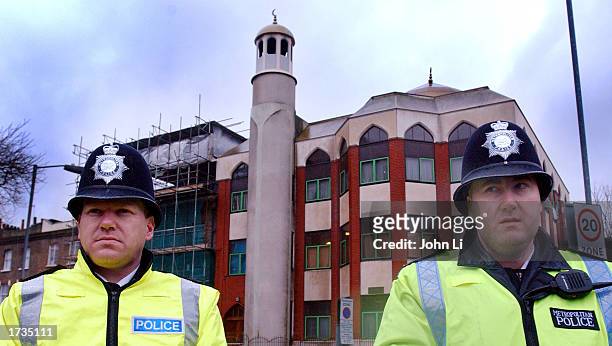 Two British police officers stand outside the Finsbury Park Mosque after police conducted a raid in the early morning hours resulting in the arrest...