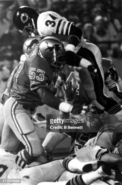 Garry Cobb of the Detroit Lions tries to tackle Walter Payton of the Chicago Bears during an NFL game circa 1982 at the Pontiac Silverdome in...