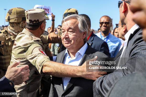 Protesters raise signs in solidarity with Palestinians in the Gaza Strip as Egyptian army officers and bodyguards escort United Nations...