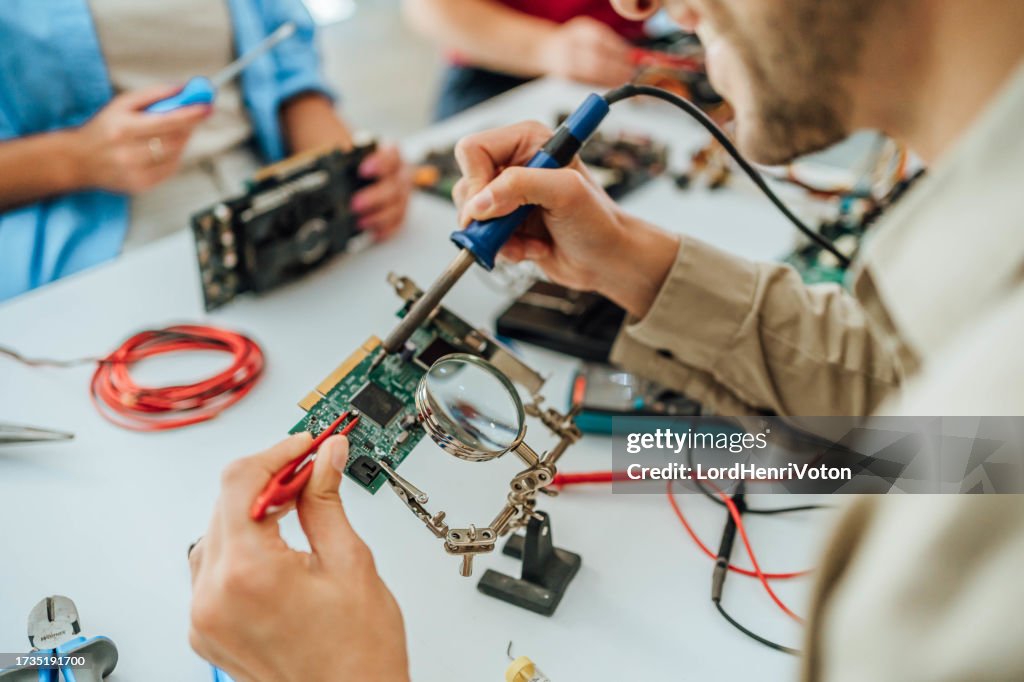 Man is fixing the electrical components of a computer