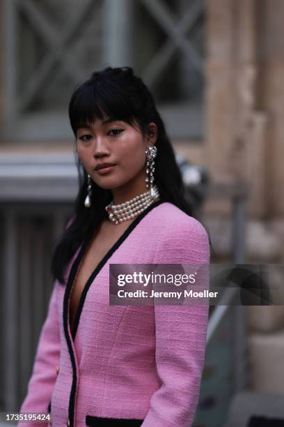 Jihoon Kim is seen wearing a pink knit blazer with black edges, a pink knit skirt, white lace overknees, black high heels, multilayer pearl necklace,...