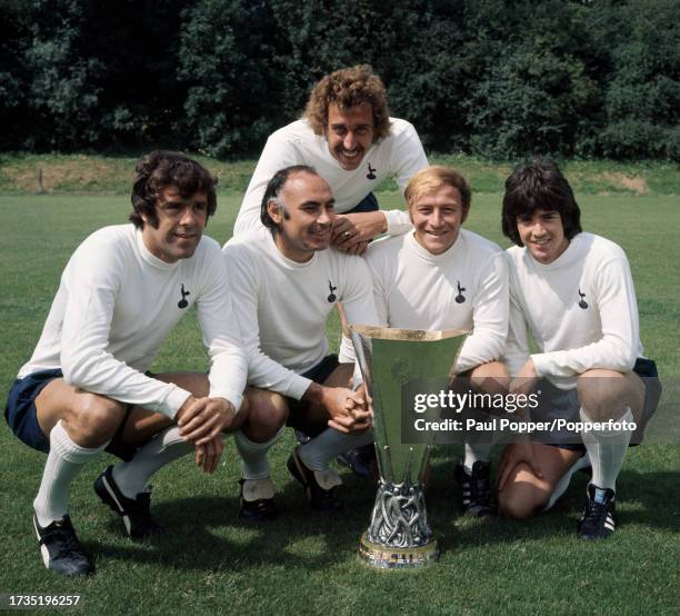 Tottenham Hotspur footballers Mike England, Alan Glizean, Martin Chivers , Ralph Coates and Joe Kinnear pose with the UEFA Cup at Cheshunt training...