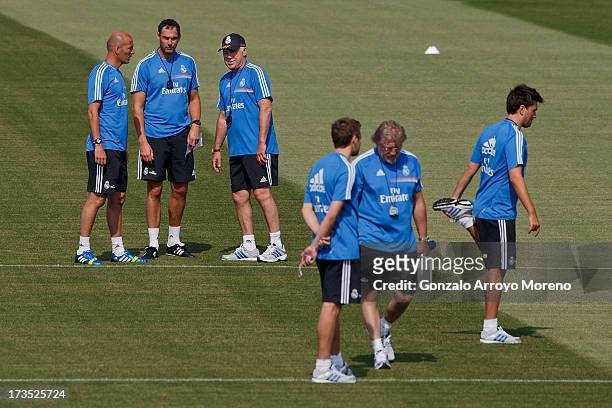 Head coach Carlo Ancelotti of Real Madrid looks on with assistant coach Paul Clement and Zinedine Zidane with other members of Real madrid technical...