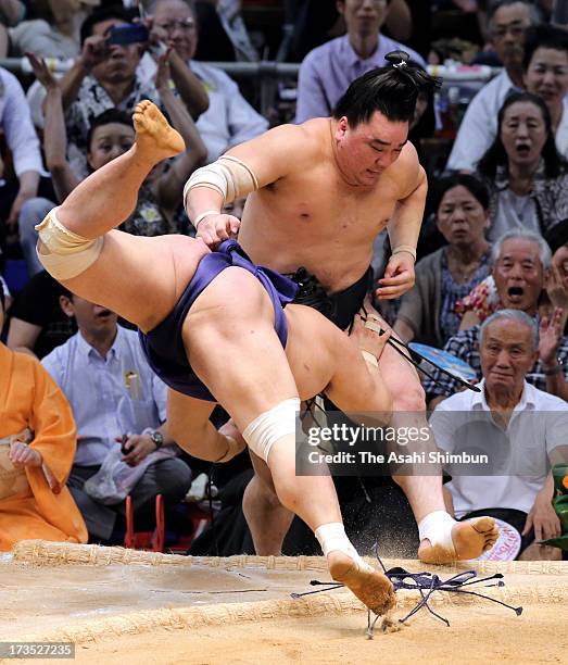 Myogiryu pushes out Mongolian Yokozuna, sumo's grand champion Harumafuji , whose real name is Altangadasyn Khuchitbaatar to win during day nine of...